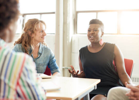 Candid picture of a business team collaborating. Filtered series with light flares, bokeh and warm sunny tones.